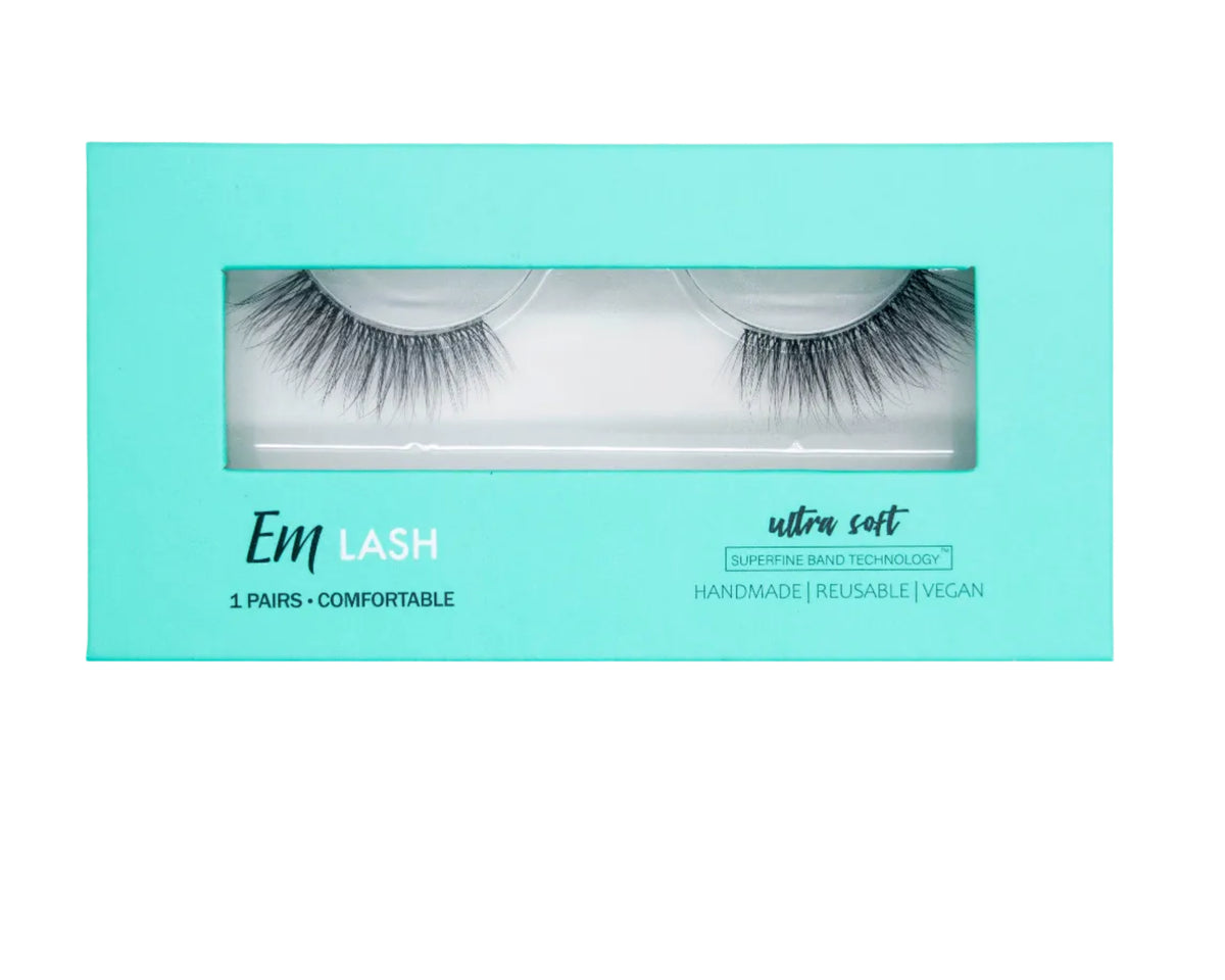 A pair of black false eyelashes in a mint green rectangular box labeled 'Em LASH ultra soft'.