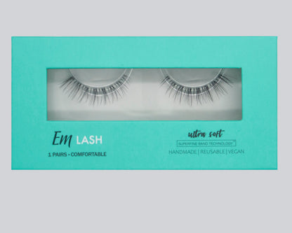 Em Lash false eyelashes in a mint green box with a clear window showing the lashes inside. The packaging features white and black text detailing the product features.