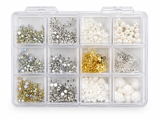 A clear plastic organizer box with 12 compartments filled with assorted craft embellishments, including white pearls, silver and gold rhinestones, white flower-shaped beads, and metallic charms, shown on a white background.