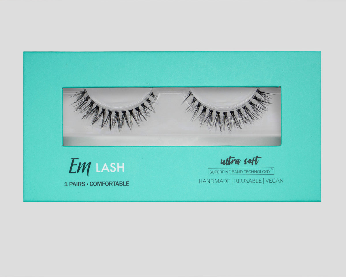 Em Lash reusable false eyelashes in a turquoise and white box, displayed against a neutral gray background.